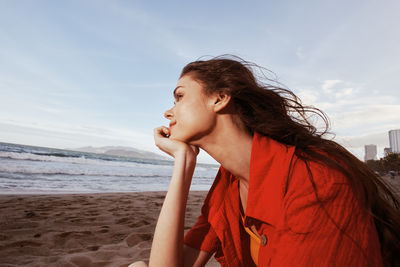 Young woman looking away at beach