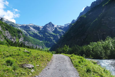 Road amidst plants and mountains against sky