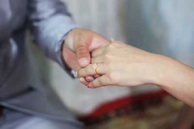 Midsection of couple holding hands