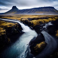 Scenic view of waterfall against sky