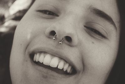 Close-up portrait of smiling young woman wearing nose ring