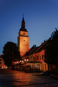 Buildings by river against clear sky