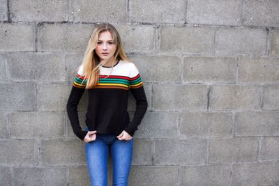 Portrait of young woman leaning on wall