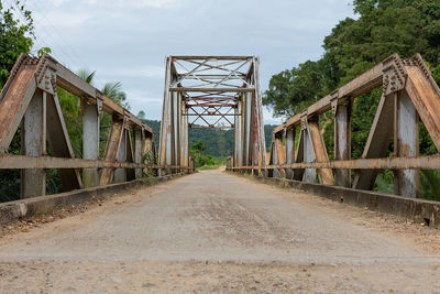 Railroad tracks by bridge against sky