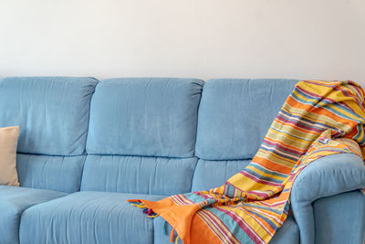 Low section of woman sitting on sofa at home