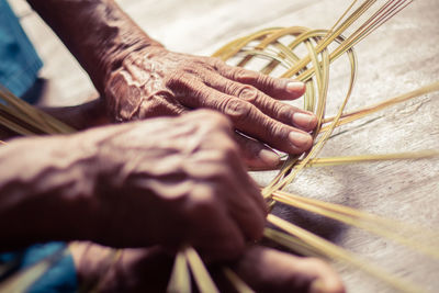 Cropped hands making wicker basket