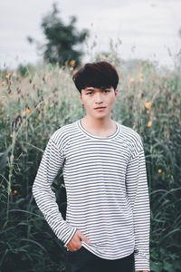 Portrait of young man standing on field