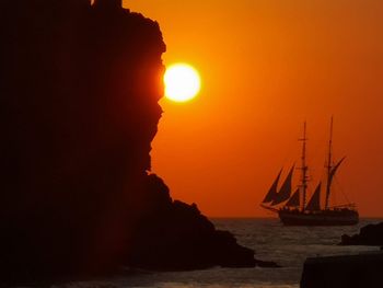 Silhouette sailboats in sea against sky during sunset