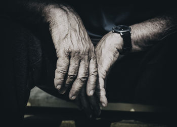 Midsection of man sitting in darkroom