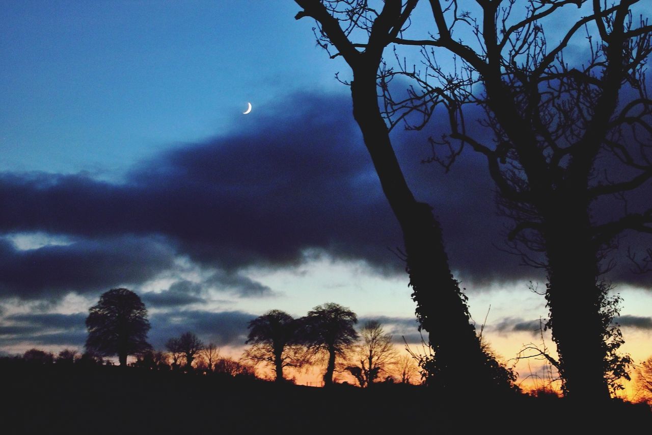 sky, scenics, low angle view, beauty in nature, tranquility, cloud - sky, tranquil scene, tree, nature, weather, silhouette, dusk, idyllic, reflection, bare tree, mountain, cloudy, outdoors, moon, no people