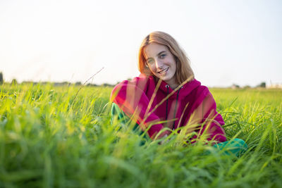 Portrait of young woman standing amidst wheat field