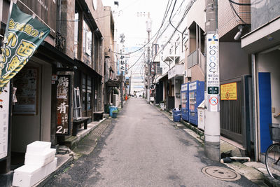 Empty road amidst buildings in city