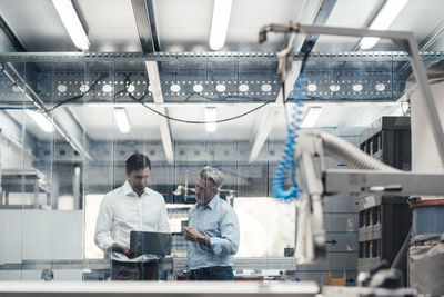 Expertise working on laptop while standing in workshop at industry