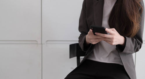 Midsection of woman using mobile phone