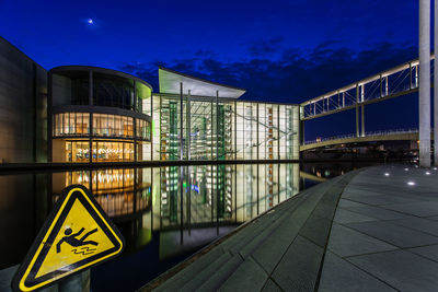 Illuminated buildings against clear sky at night