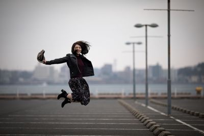 Young woman in mid-air against clear sky