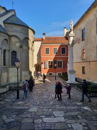 People walking on street amidst buildings in city