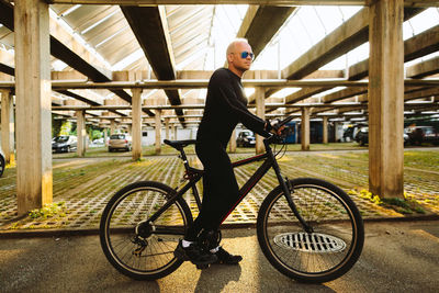 Full length side view of mid adult man with bicycle