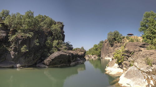 Panoramic view of rocks and trees against clear sky