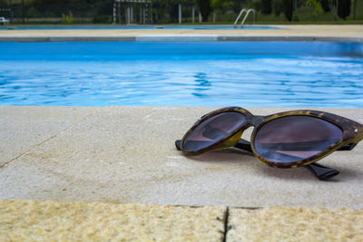 Sunglasses next to the swimming pool