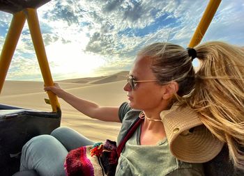 Woman sitting in vehicle at desert