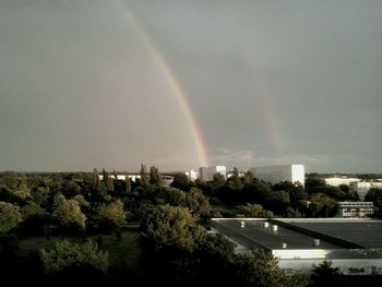 Rainbow over city against sky