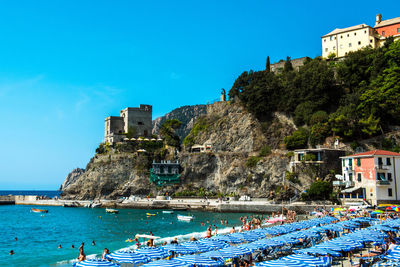 People swimming in sea against blue sky