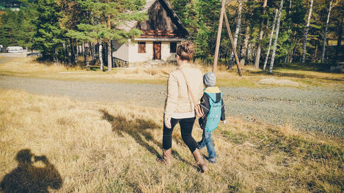 Rear view of woman with son walking in park