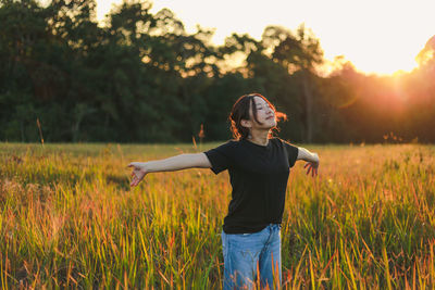 Full length of young woman standing on field