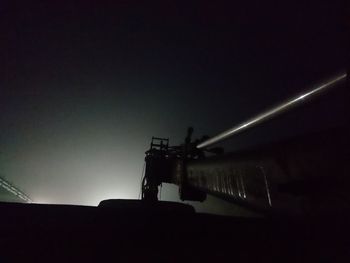 Low angle view of silhouette building against sky at night