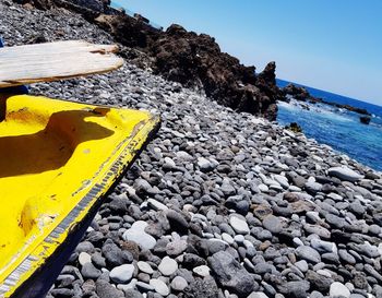 Yellow stones on beach against sky