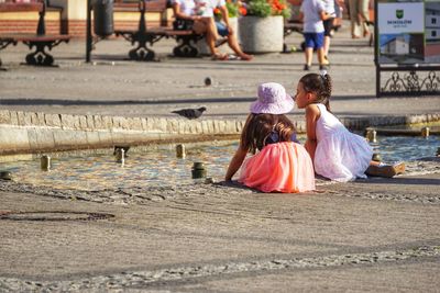 Rear view of women sitting on street