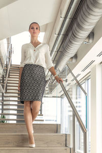 Portrait of woman standing on staircase