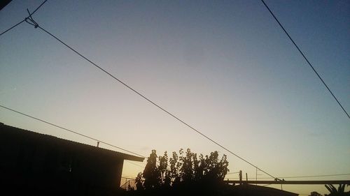 Low angle view of power cables against clear sky