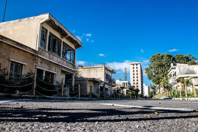 Street amidst buildings against clear blue sky