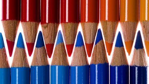 Close-up of multi colored pencils against blue background