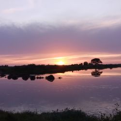 Scenic view of lake against romantic sky at sunset