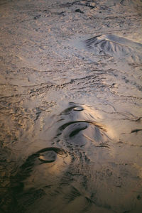 High angle view of footprints on wet sand