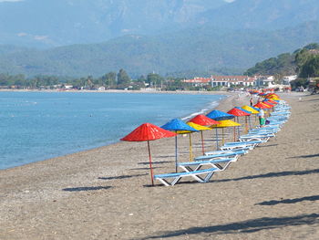 Deck chairs on beach against sea