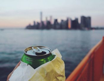 Close-up of green tin can against sea