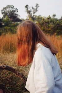 Rear view of woman standing on field