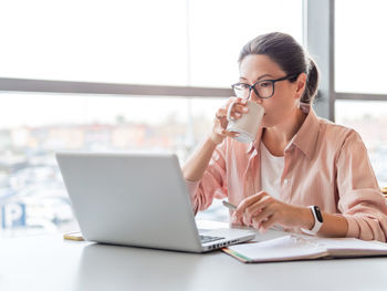 Young woman using laptop at office