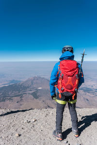 Rear view of man standing on mountain