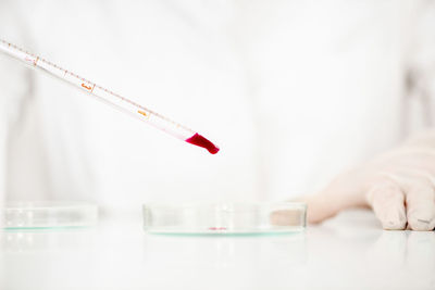 Cropped hand of scientist with blood in pipette