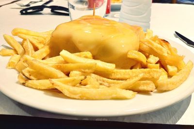 Close-up of burger and fries in plate on table