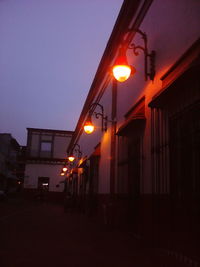 Illuminated street light in city at dusk