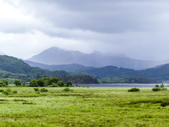 Scenic view of field and mountains against sky