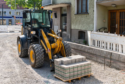 Yellow truck with pallet road tiles at a construction site in the city.