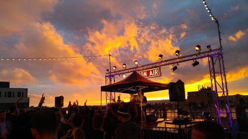 People in city against sky during sunset