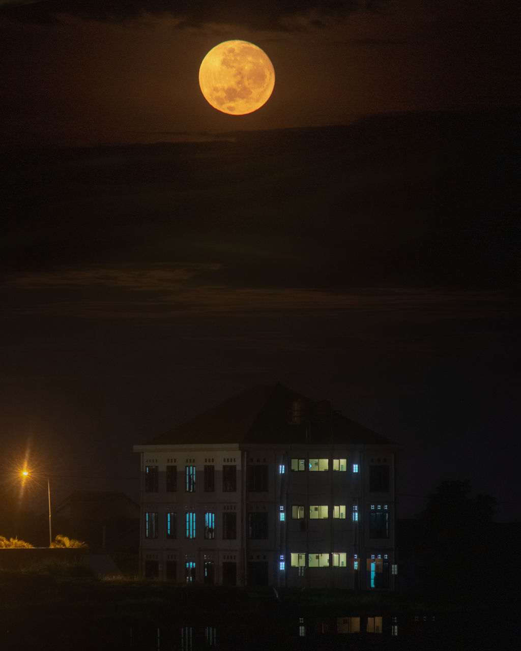 VIEW OF ILLUMINATED BUILDING AGAINST SKY AT NIGHT